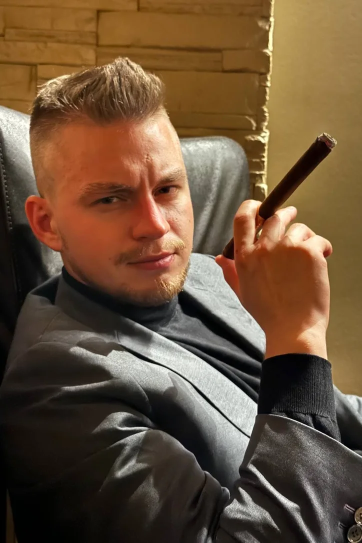 Anatolie Clevan in a leather chair, holding a cigar