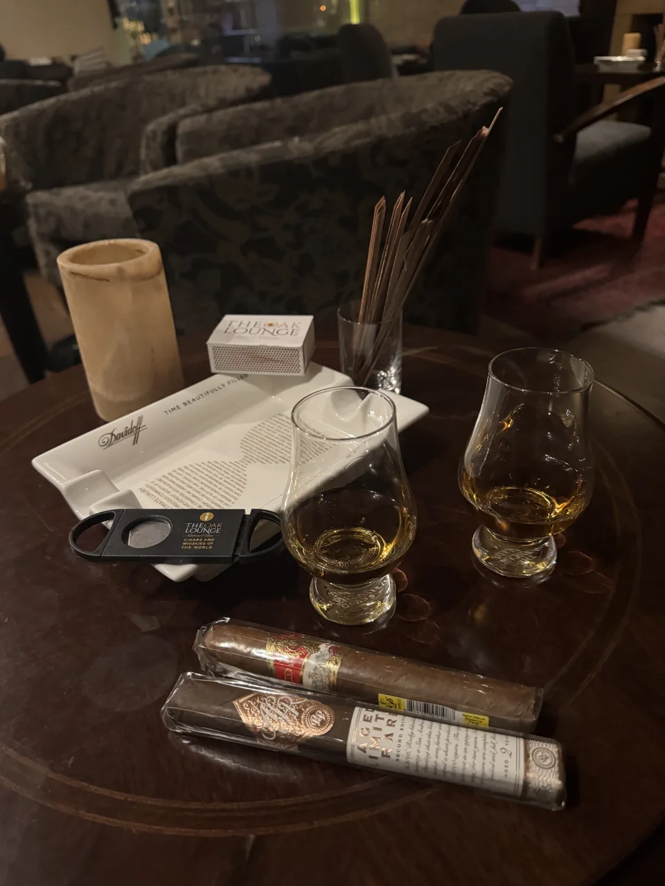 Two cigars, whisky glasses and a cutter on a lounge table, from Anatolie's photos